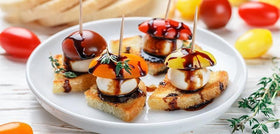 Mozzarella cheese with balsamic glaze and tomatoes on mini toasts
