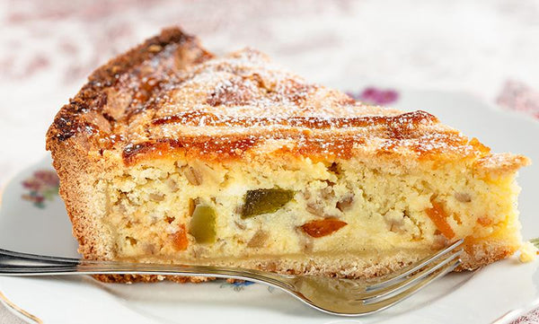 Slice of Pastiera Cake with Candied Fruit and Powdered Sugar